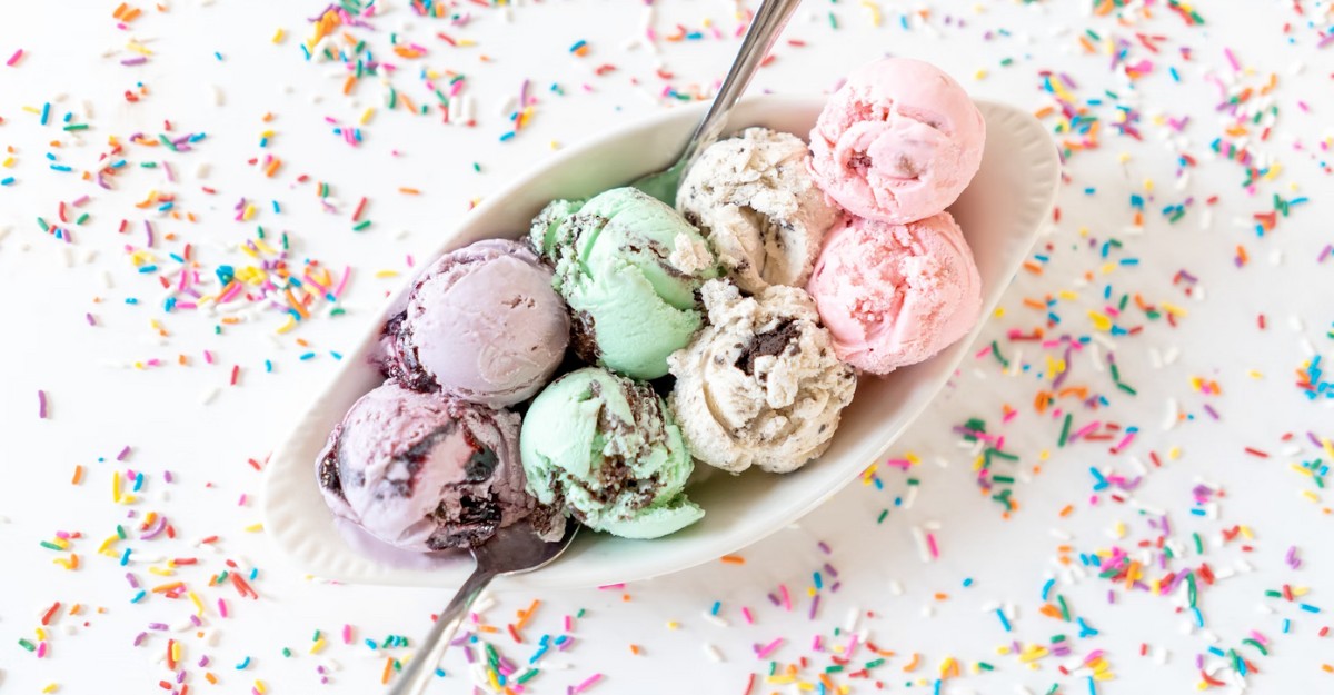 A bowl of ice cream surrounded by sprinkles on a white table. (Photo: Courtney Cook / Unsplash)
