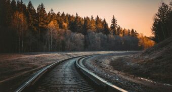 A photo of a railway in a wooded area. (Photo: Irina Iriser / Unsplash)