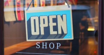 An open sign is seen in a store window.