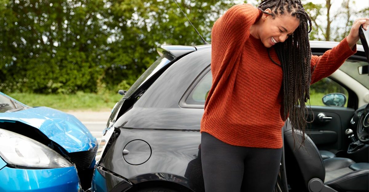 whiplash-disability-claim-denied-ontario A woman rubs her neck after experiencing painful whiplash in a car accident.