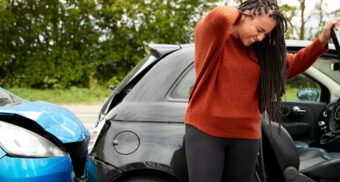 whiplash-disability-claim-denied-ontario A woman rubs her neck after experiencing painful whiplash in a car accident.