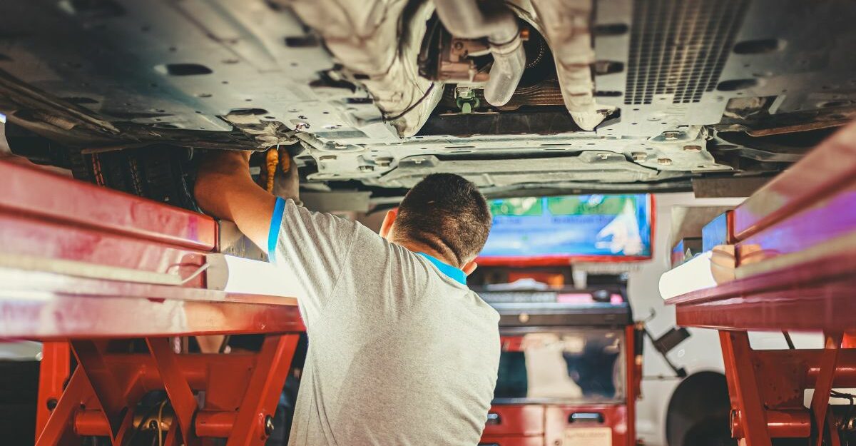 An auto mechanic does a repair on a vehicle at an autobdy collision repair shop in Canada.