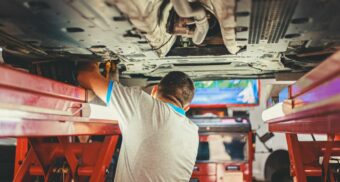 An auto mechanic does a repair on a vehicle at an autobdy collision repair shop in Canada.