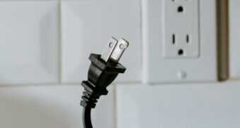 A close-up of an unplugged power cord near a wall outlet, symbolizing the right to disconnect from work in Alberta.