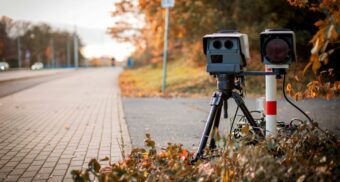 Mobile speed camera set up on a roadside in autumn, used for traffic enforcement.