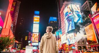 A young man gazes at the numerous digital advertisements in Times Square.