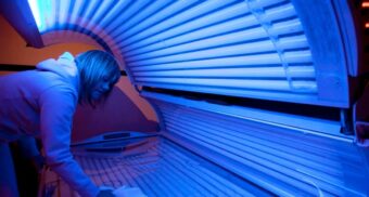A worker cleans a tanning bed. (Photo: Jonathan Hayward / The Canadian Press)