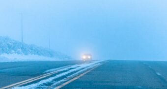 A vehicle driving on a road following a snowstorm. (Photo: Ross Stone / Unsplash)