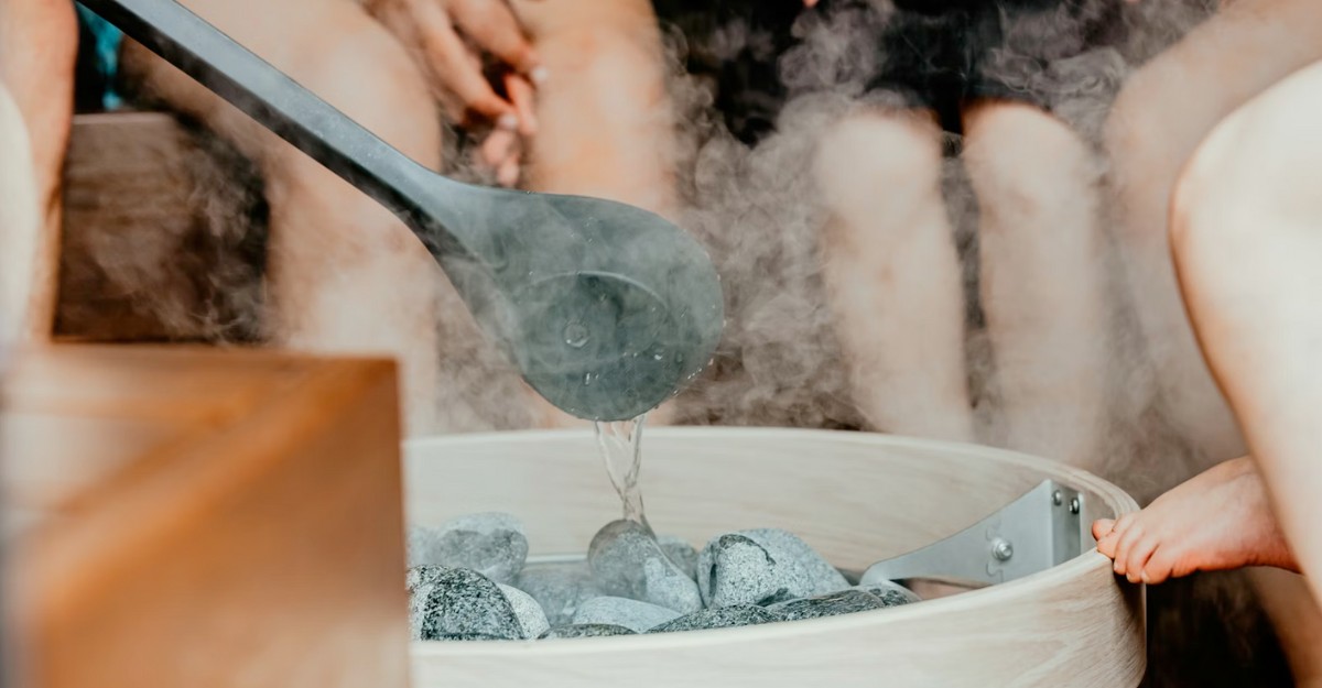 A group of people sitting in a sauna. (Photo: huumsauna / Unsplash)