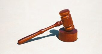 A brown gavel on a white surface. (Photo: Tingey Injury Law Firm / Unsplash)