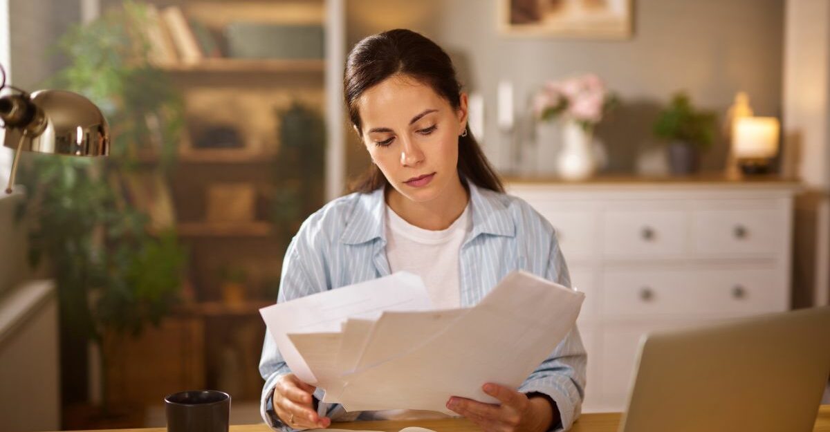 Woman reviewing paperwork at home about who qualifies for long term disability in BC