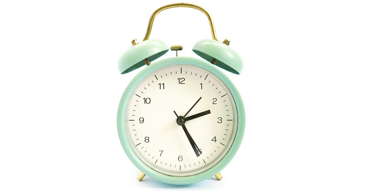 A green clock in front of a white background. (Photo: Abdul A / Unsplash)