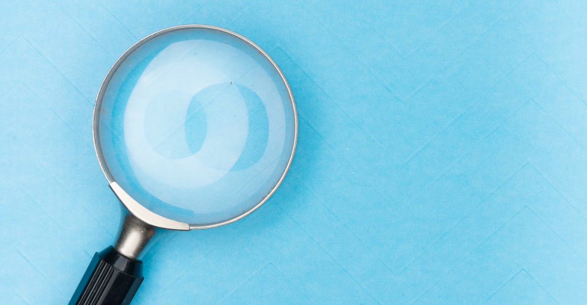 A magnifying glass on a blue background. (Photo: Markus Winkler / Unsplash)
