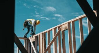 A construction worker securing wooden beams. (Photo: Josh Olalde / Unsplash)
