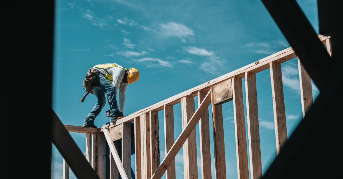 A construction worker securing wooden beams. (Photo: Josh Olalde / Unsplash)