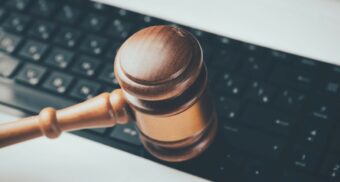 A wooden gavel in front of a laptop. (Photo: Sasun Bughdaryan / Unsplash)