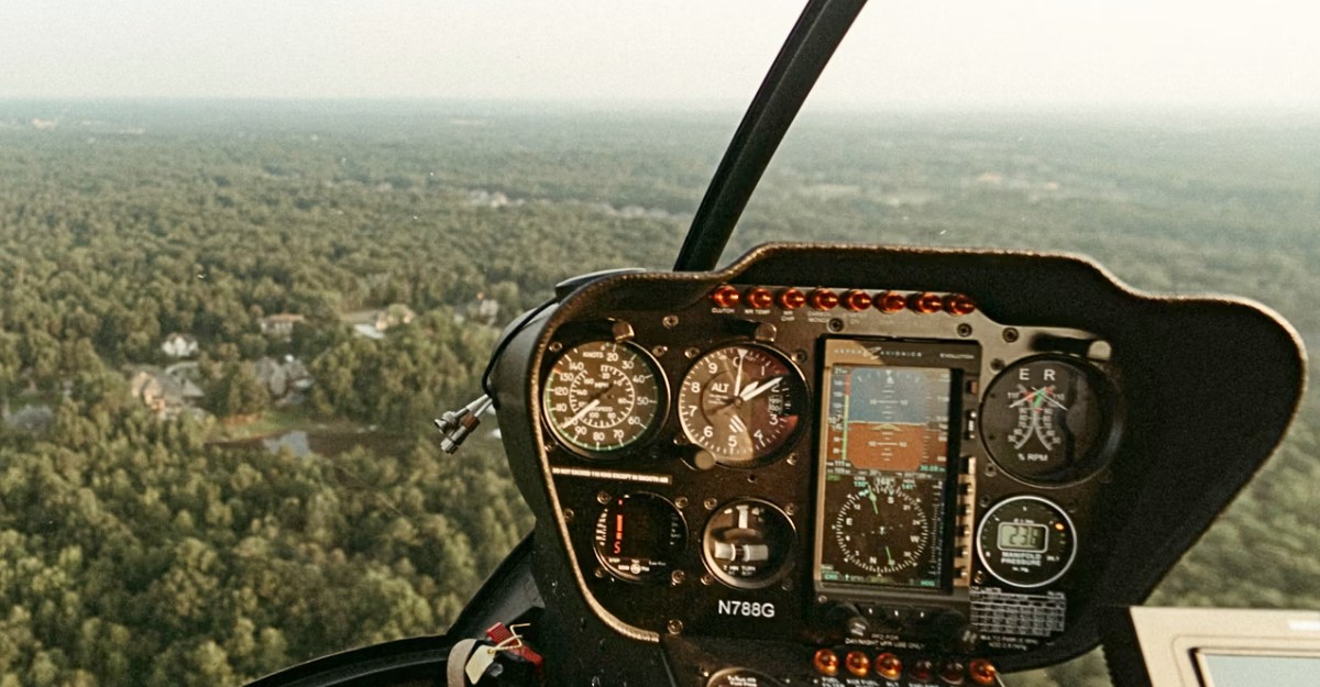 A helicopter pilot flying above a forest. (Photo: Isaac Macdonald / Unsplash)
