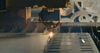 A machine cuts metal using a laser. (Photo: Cemrecan Yurtman / Unsplash)