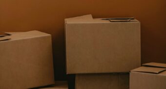 Cardboard boxes against a brown wall. (Photo: Kadarius Seegars / Unsplash)