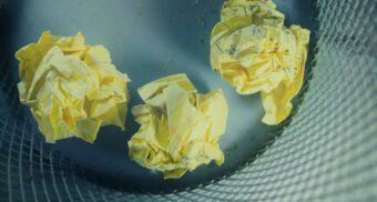 Balls of yellow paper in a trash bin. (Photo: Steve A Johnson / Unsplash)