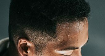 A man with sweat dripping from his forehead. (Photo: Nathan Dumlao / Unsplash)