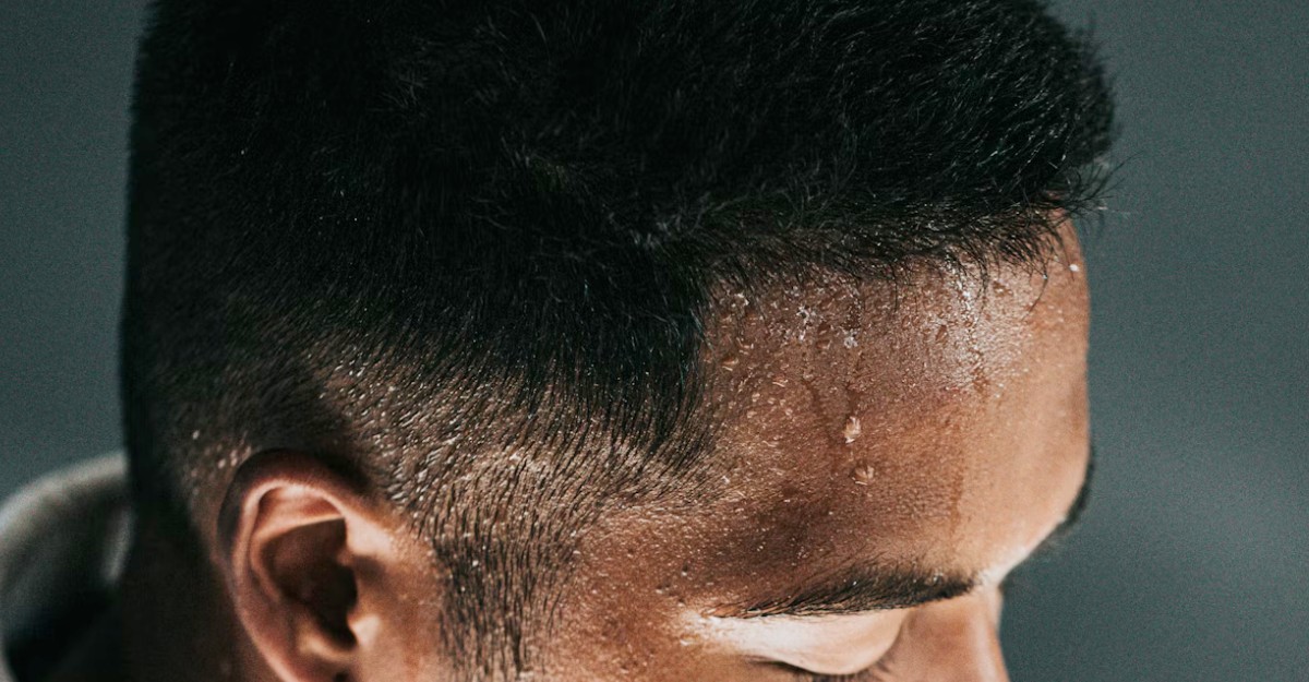 A man with sweat dripping from his forehead. (Photo: Nathan Dumlao / Unsplash)