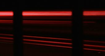 Red light coming from a machine in a dark room. (Photo: Matthew Feeney / Unsplash)