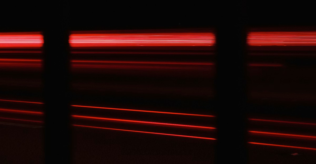 Red light coming from a machine in a dark room. (Photo: Matthew Feeney / Unsplash)