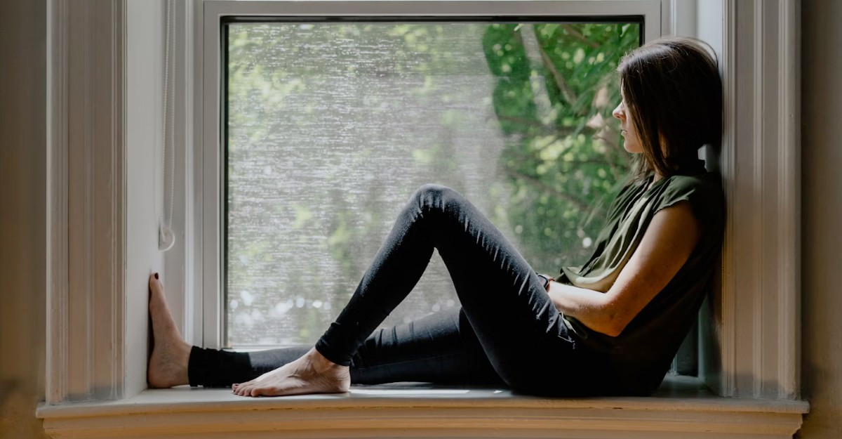 A depressed woman looks out a window. (Photo: Kelly Sikkema / Unsplash)